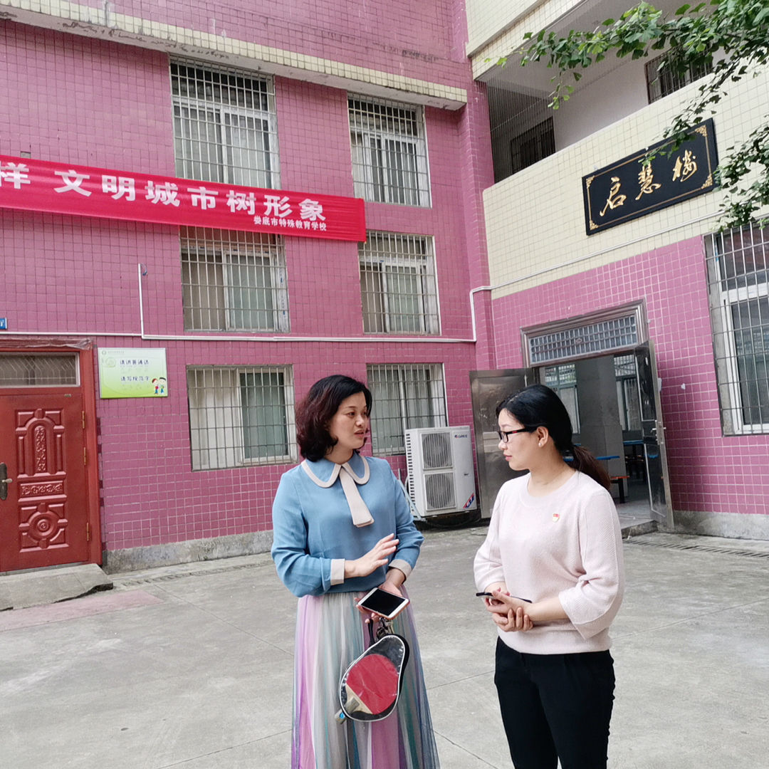 (KY官网学生第二党支部书记朱燕聪与特殊学校校长交谈学生情况)